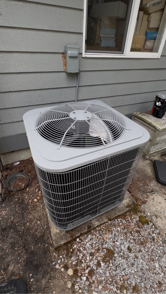 Outdoor condenser unit installed beside a house, top view